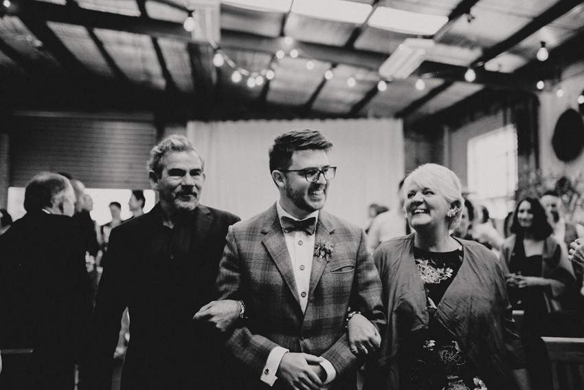 Groom walking down the aisle with his parents