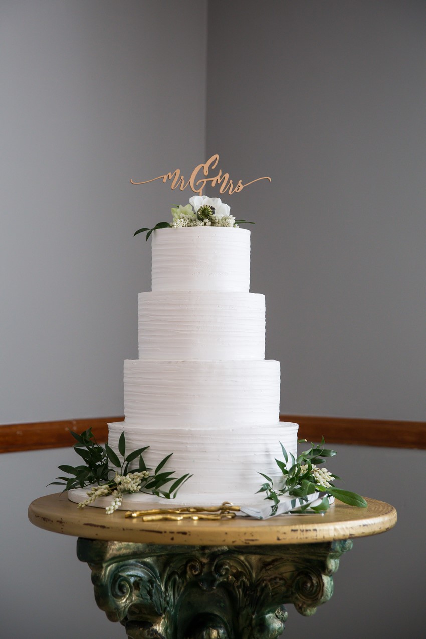 White Wedding Cake Decorated with Greenery & Lasercut Topper
