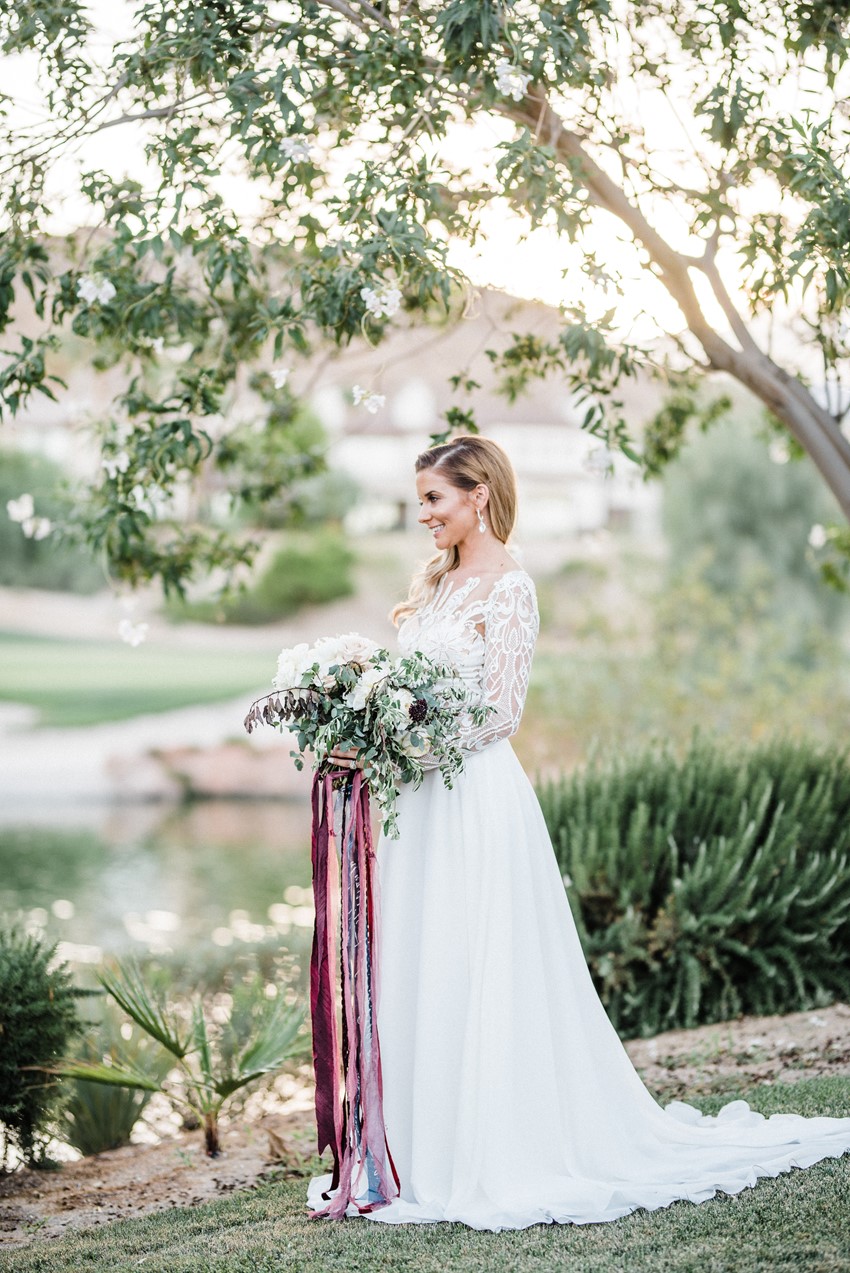 Bride in Long Sleeve Wedding Dress with Bouquet & Trailing Ribbons
