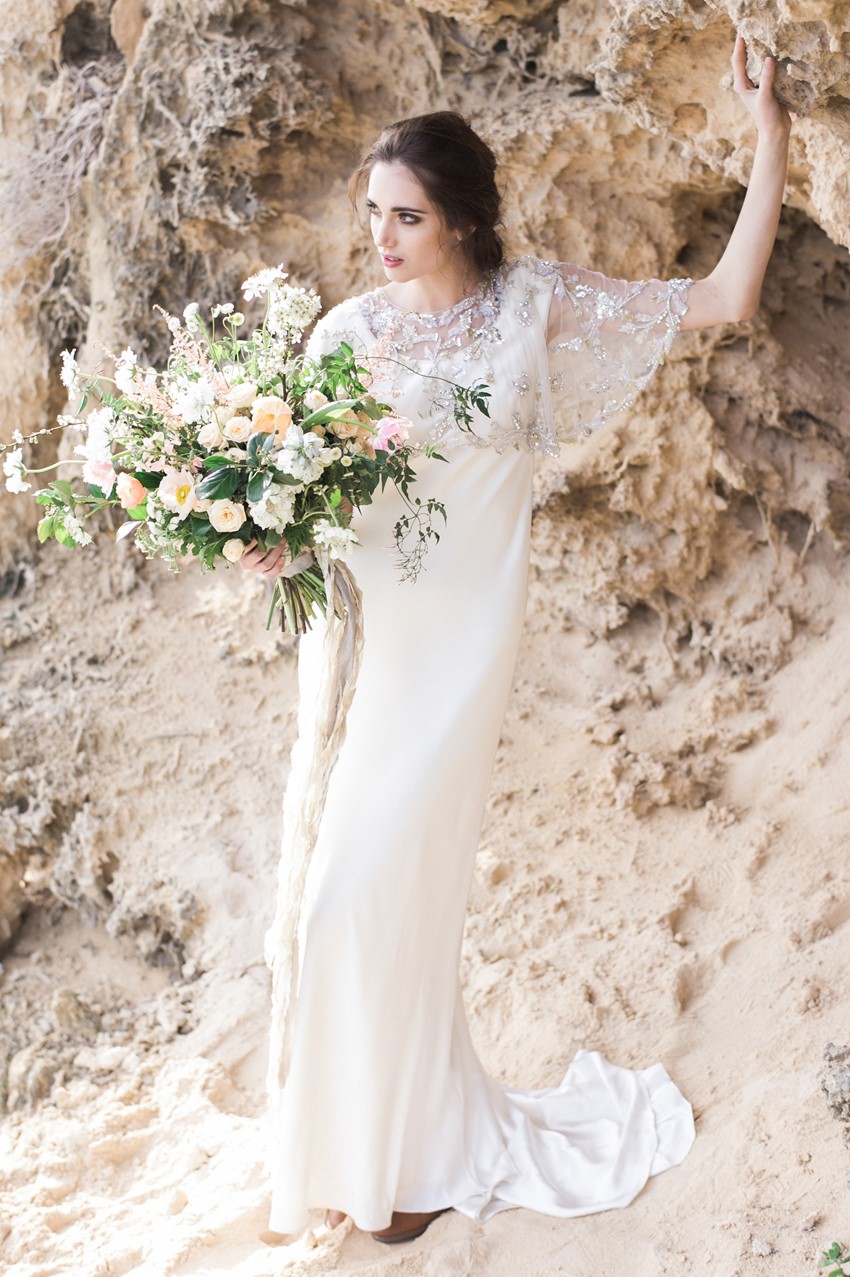 Elegant bride in a cape with an organic bouquet